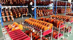 Guía de selección de instrumentos de cuerda al por mayor, con violines y estuches en la sala de exposición de la fábrica