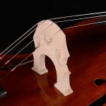 Professional double bass bridge close-up on spruce top, clean fit and string alignment